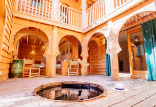 Innenhof der Lodge „Riad“ im Domaine EcÔtelia, Frankreich, mit Holzinterieur, runden Bögen und kleinem Whirlpool.