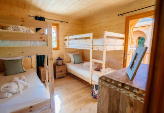 Innenaufnahme eines gemütlichen Holzraums mit zwei Etagenbetten in der Lodge 'Riad' bei Domaine EcÔtelia, Frankreich.