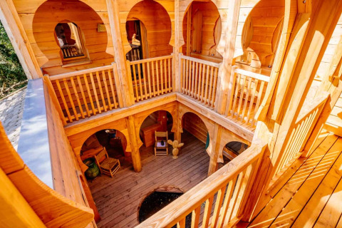 Holzinterieur der Lodge „Riad“ im Domaine EcÔtelia, Frankreich, mit rustikalen Bögen und Innenhof.