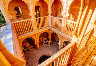 Holzinterieur der Lodge „Riad“ im Domaine EcÔtelia, Frankreich, mit rustikalen Bögen und Innenhof.