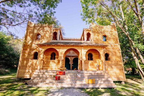 Lodge 'Riad' im Domaine EcÔtelia, Frankreich, mit markanter Holzarchitektur und grüner Umgebung.