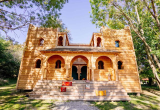 Lodge 'Riad' im Domaine EcÔtelia, Frankreich, mit markanter Holzarchitektur und grüner Umgebung.