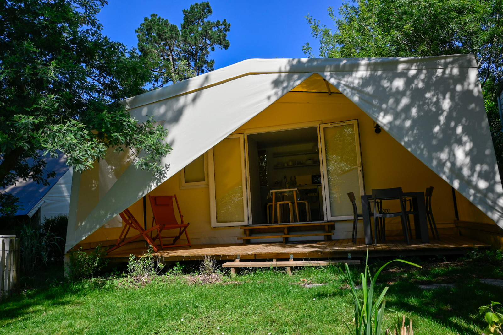 Cocosweet safari tent ecolodge bij Ushuaïa Villages Le Parc de la Grève in Frankrijk, met terras en stoelen.