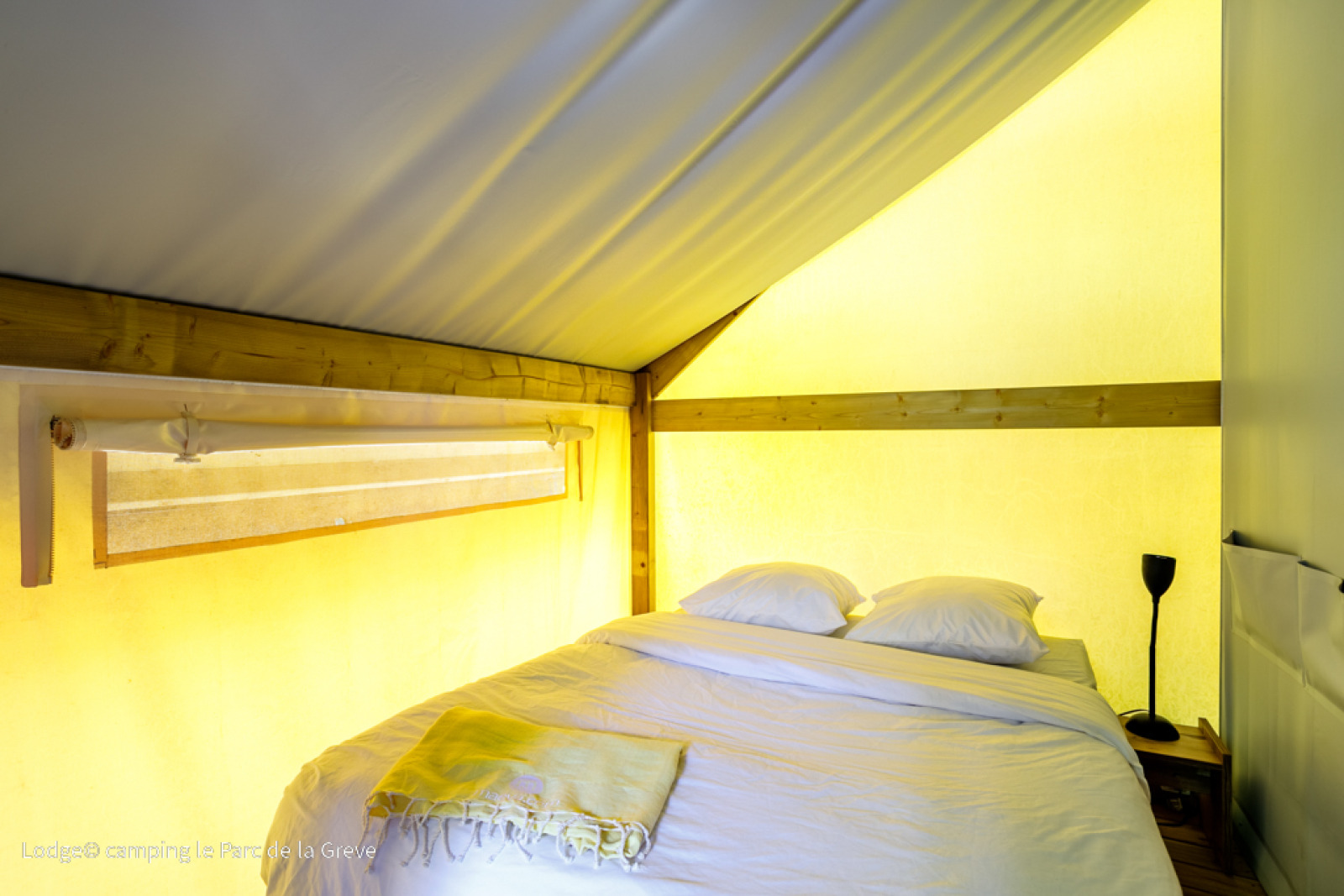 Sfeervol ingerichte slaapkamer met tweepersoonsbed in de Ecolodge Tent bij Le Parc de la Grève in Frankrijk.