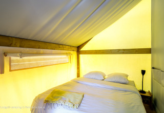 Chambre chaleureuse avec lit double dans la tente Ecolodge à Ushuaïa Villages Le Parc de la Grève, France.