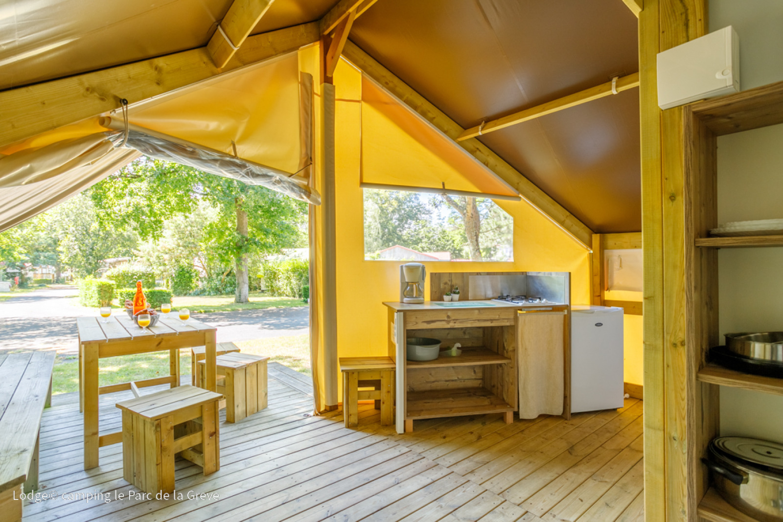 Interieur van Ecolodge Tent bij Ushuaïa Villages Le Parc de la Grève, Frankrijk, met houten meubels.