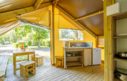 Intérieur d'une tente Ecolodge à Ushuaïa Villages Le Parc de la Grève, France, avec meubles en bois.