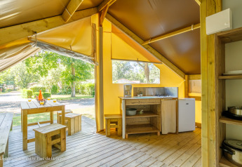 Intérieur d'une tente Ecolodge à Ushuaïa Villages Le Parc de la Grève, France, avec meubles en bois.