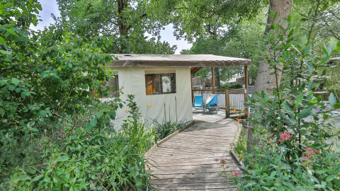 Safari tent ‘Sahari Ecotent Mindervaliden’ met houten loopbrug in het groen bij Ushuaïa Villages Le Parc de la Grève.