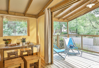 Safaritent 'Sahari Ecotent Mindervaliden' bij Ushuaïa Villages Le Parc de la Grève in Frankrijk met houten terras.