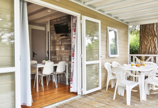 Binnen- en buiteneethoek van het Relax Chalet met twee slaapkamers, moderne meubels en houten terras.