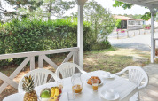 Terrazza esterna al Relax Chalet con tavolo bianco, sedie, frutta, succo e tanto verde in Francia