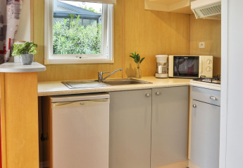 Cocina moderna con fregadero, nevera, microondas y cafetera en Relax Chalet en Ushuaïa Villages Le Parc de la Grève.
