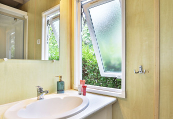 Baño del Relax Chalet con lavabo, ventanas abiertas y espejo en Ushuaïa Villages Le Parc de la Grève, Francia.