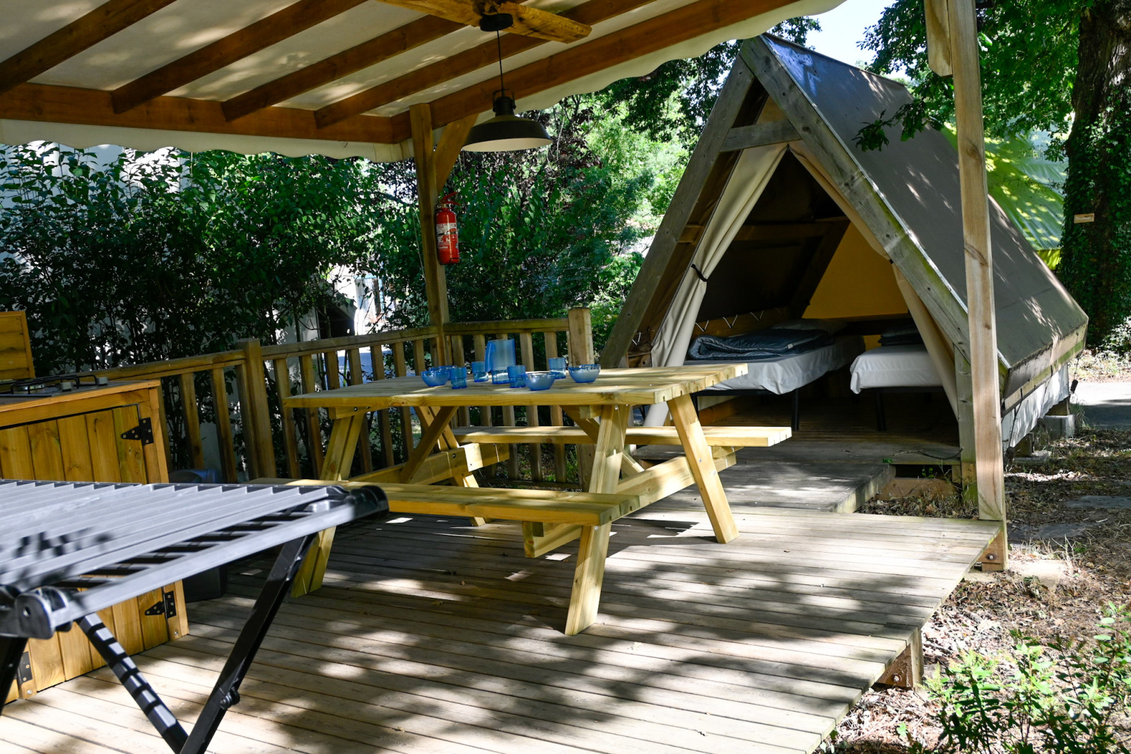 Backpackers safaritent bij Ushuaïa Villages Le Parc de la Grève met overdekt terras en houten tafel.