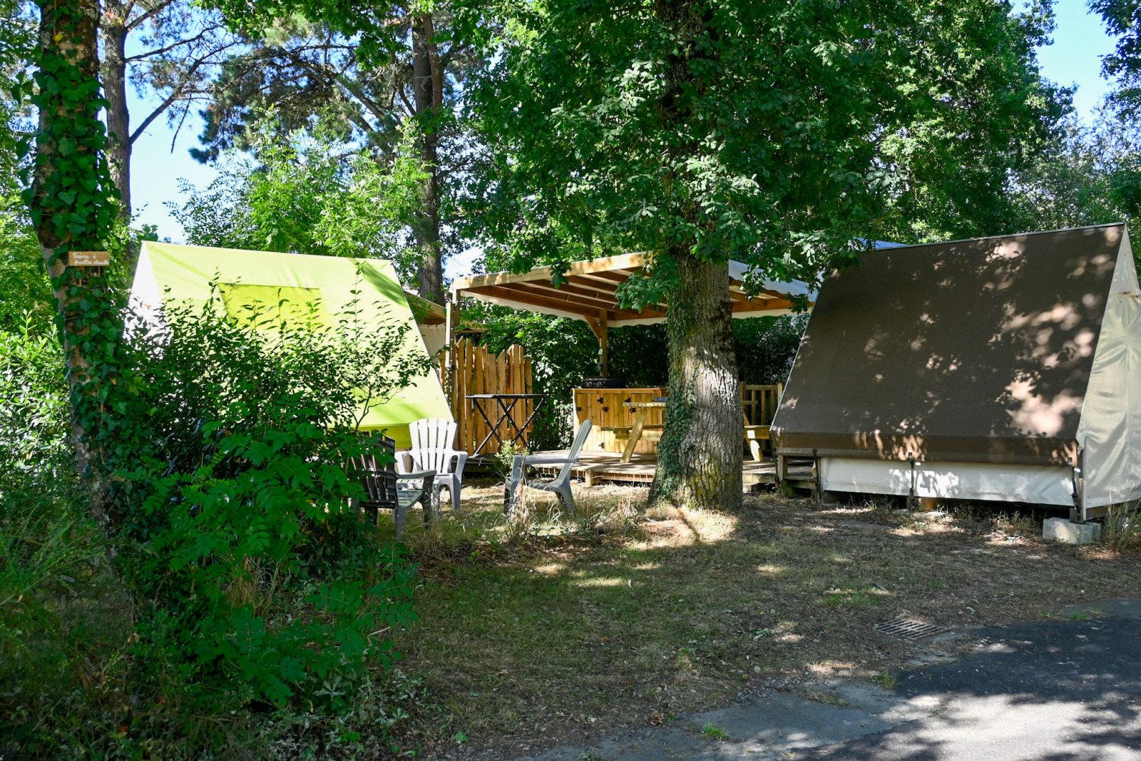 Backpackers safari tenten bij Ushuaïa Villages Le Parc de la Grève, Frankrijk, met buitenzitje en bomen.