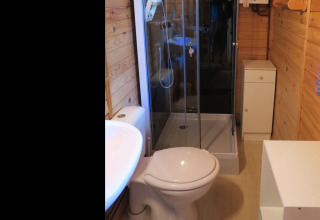 Moderne badeværelse i træchalet på Ushuaïa Villages Le Parc de la Grève med brusekabine og toilet.