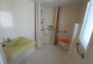 Bagno accessibile in una casa mobile al Flower Camping La Pointe du Talud, dotato di maniglioni e doccia.