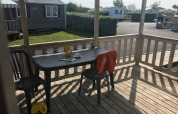 Blick von der Holzterrasse eines Mobile Homes Comfort PMR HELIOS im Flower Camping La Pointe du Talud, Frankreich.