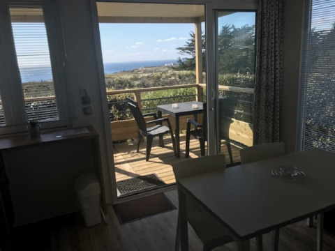 Vue depuis l'intérieur du Mobile home «Premium LIVING» au Flower Camping La Pointe du Talud, terrasse et mer.