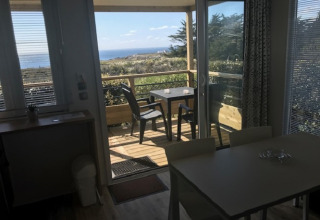 Vista dall’interno di Mobile home «Premium LIVING» al Flower Camping La Pointe du Talud, terrazza e mare.