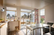 Helles, modernes Wohnzimmer in einem Premium Mobilheim auf Flower Camping La Pointe du Talud in Frankreich.