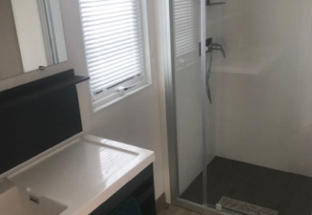 Salle de bain moderne dans un mobil-home avec douche et lavabo au Flower Camping La Pointe du Talud en France.