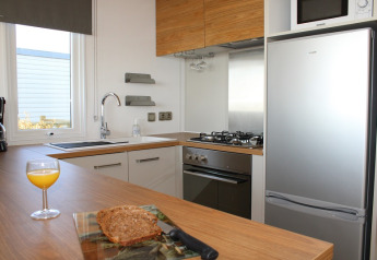 Modern kitchen in the Premium HORIZON mobile home at Flower Camping La Pointe du Talud, bread and juice.