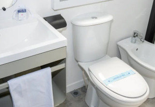 Baño moderno de Cottage Next XL Country en Trasimeno Glamping Resort, con inodoro, bidé y lavabo.
