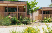 Due moderni cottage in legno, Cottage Next XL Loggia, circondati dal verde al Trasimeno Glamping Resort in Italia.