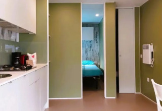 Cocina y sala modernas en Cottage Next XL Loggia Laguna en Trasimeno Glamping Resort en Italia.