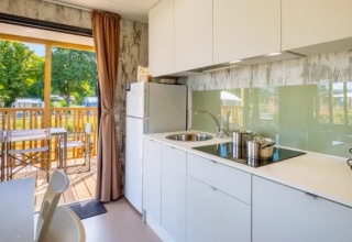 Cocina moderna en Cottage Next XL Loggia Laguna en Trasimeno Glamping Resort, vista a terraza exterior