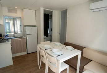 Cocina y comedor modernos con aire acondicionado en Cottage Next XL Superior, Trasimeno Glamping Resort, Italia.