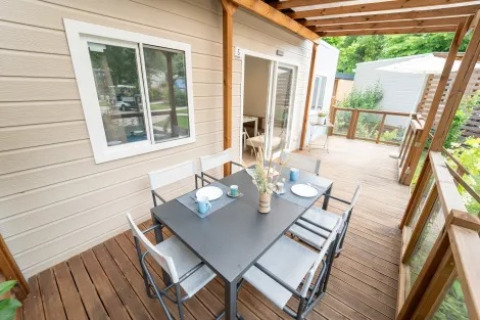 Veranda esterna del Cottage Next XL Superior al Trasimeno Glamping Resort, Italia, con tavolo da pranzo.