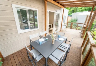 Veranda esterna del Cottage Next XL Superior al Trasimeno Glamping Resort, Italia, con tavolo da pranzo.