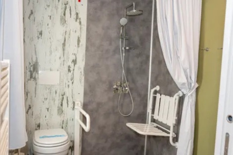 Baño adaptado con ducha, asiento plegable y WC en Cottage Next XL 4 All, Trasimeno Glamping Resort.