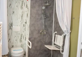 Baño adaptado con ducha, asiento plegable y WC en Cottage Next XL 4 All, Trasimeno Glamping Resort.