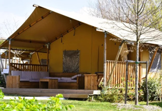Tente safari au Trasimeno Glamping Resort en Italie, avec terrasse confortable et cadre verdoyant.