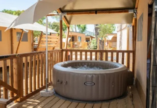 Bubbelbad op het houten terras van de Safari Tent Comfort bij Trasimeno Glamping Resort, Italië.