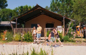 Famiglia davanti alla Safari Tent Comfort «Trasimeno» al Trasimeno Glamping Resort, immersi nella natura.