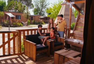 Eine Familie genießt die sonnige Terrasse eines Safari-Zeltes im Trasimeno Glamping Resort in Italien.
