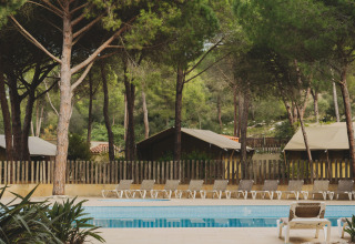 Swimmingpoolområde omgivet af træer ved Wecamp L'Escala Punta Mila feriepark i Catalonien, Spanien.