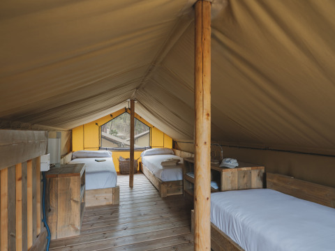 Interieur van safaritent Lodge Duplex Plus Montgrí met houten bedden bij Wecamp L'Escala Punta Mila.