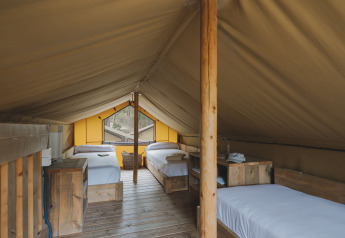 Interieur van safaritent Lodge Duplex Plus Montgrí met houten bedden bij Wecamp L'Escala Punta Mila.