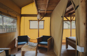 Indretning af safari-teltet Lodge Duplex Plus Montgrí med træmøbler på Wecamp L'Escala Punta Mila.