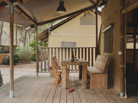Houten terras met tafel en bank aan een safarilodge bij Wecamp L'Escala Punta Mila in Spanje.