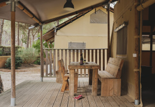 Houten terras met tafel en bank aan een safarilodge bij Wecamp L'Escala Punta Mila in Spanje.