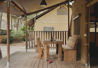 Houten terras met tafel en bank aan een safarilodge bij Wecamp L'Escala Punta Mila in Spanje.