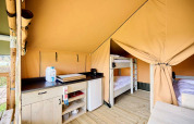 Binnenaanzicht van de Compact safaritent op Camping Les Bois du Bardelet met keuken en stapelbedden.