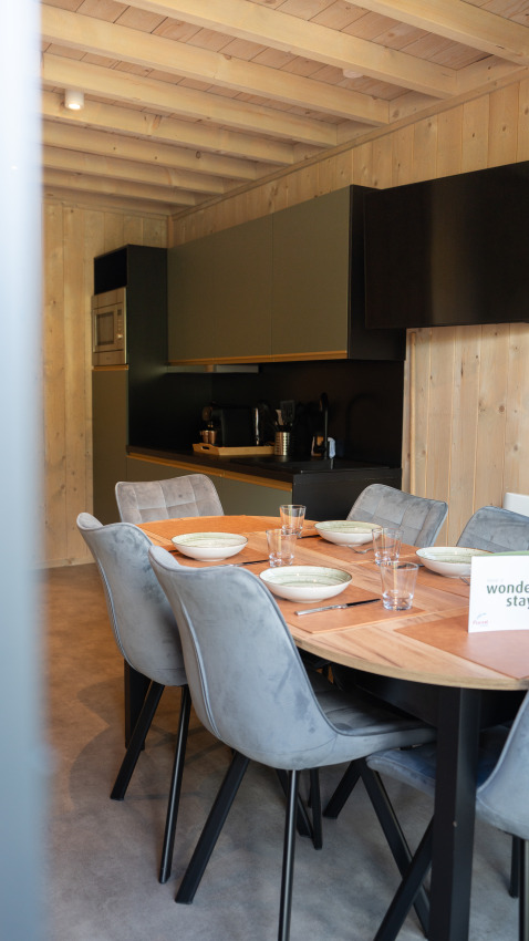 Dining area and kitchen inside Ecolodge - Care accessible at Hameau de l'Ourthe in Belgium with modern décor.